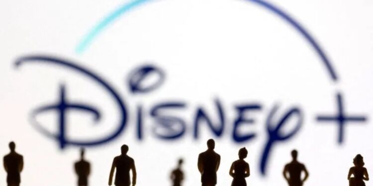 Sosok mainan orang terlihat di depan logo Disney + yang ditampilkan dalam ilustrasi. (MASAPNEWS/ANT/REUTERS)