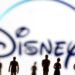Sosok mainan orang terlihat di depan logo Disney + yang ditampilkan dalam ilustrasi. (MASAPNEWS/ANT/REUTERS)