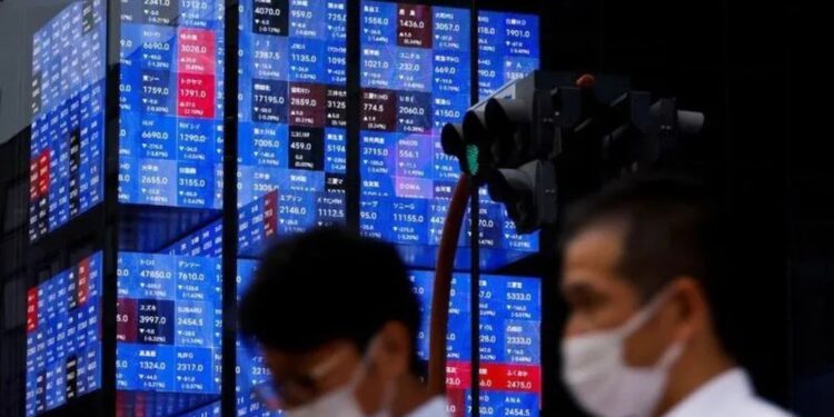 Arsip Foto - Orang-orang melewati layar elektronik yang menunjukkan indeks harga saham Nikkei Jepang di dalam sebuah aula konferensi di Tokyo, Jepang, Selasa (14/6/2022). (MASAPNEWS/ANTARA/REUTERS)