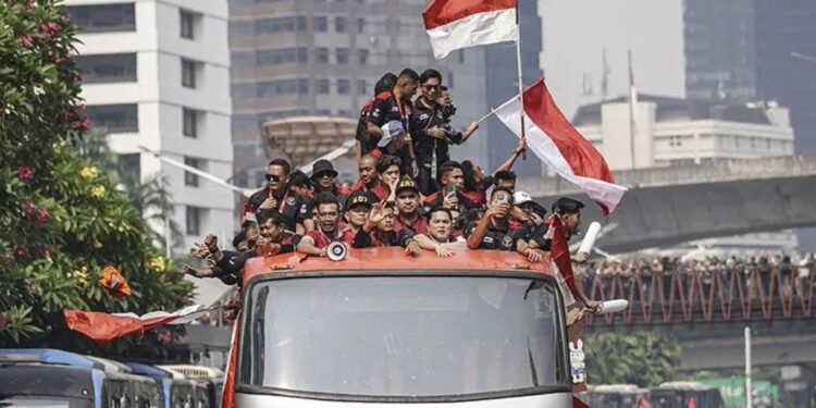 Pesepak bola Timnas Indonesia U-22 bersama ofisial dan pengurus PSSI berada di atas bus saat mengikuti arak-arakan di Jalan Jenderal Sudirman, Jakarta, Jumat (19/5/2023). (MASAPNEWS/ANT)