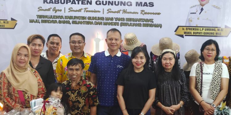 Bupati Gunung Mas Jaya S Monong, Ketua TP PKK Mimie Mariatie Jaya S Monong, dan lainnya berfoto bersama di stan Kabupaten Gunung Mas pada Kalteng Expo 2023 di Palangka Raya. (Foto : Diskominfosantik Kabupaten Gunung Mas)