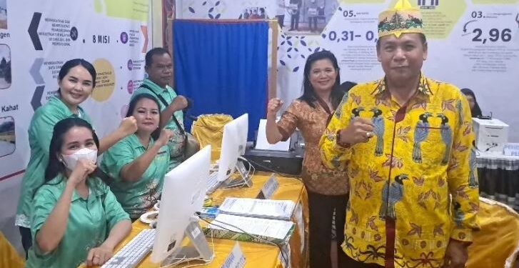 Legislator Kabupaten Gunung Mas Punding S Merang bersama Kabid Pelayanan Pencatatan Sipil Iis Yukensi dan lainnya, berfoto bersama di stan pameran pembangunan di Stadion Mini Kuala Kurun, Sabtu (17/6/2023). (IST)