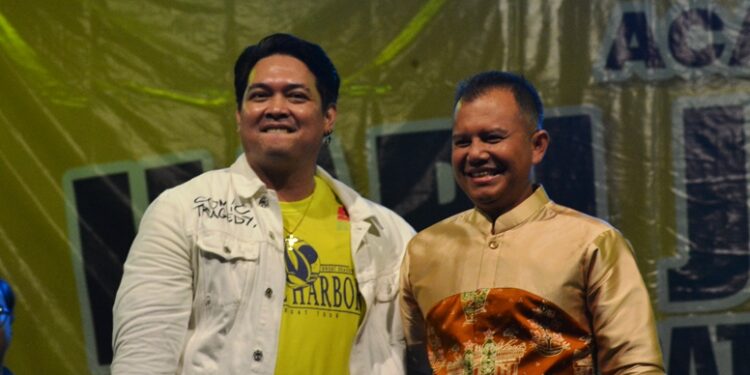 Donnie Sibarani dan Bupati Gunung Mas Jaya S Monong bernyanyi bersama saat malam puncak HUT ke-21 kabupaten, di Stadion Mini Kuala Kurun, Rabu (21/6/2023). (Foto : Diskominfosantik Gunung Mas)
