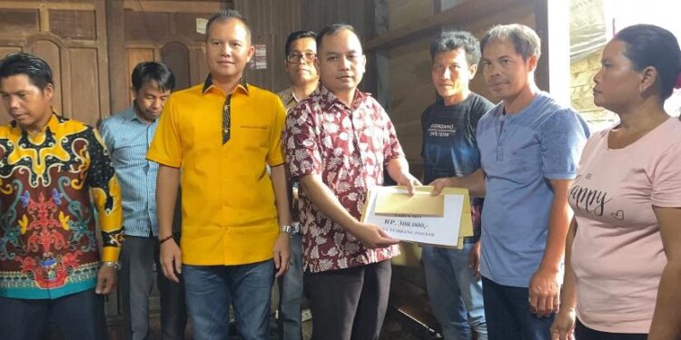 Anggota DPRD Kabupaten Gunung Mas Evandi didampingi Bupati Jaya S Monong ikut menyalurkan BLT DD secara simbolis kepada sejumlah KPM di Desa Tumbang Ponyoi, Kecamatan Kahayan Hulu Utara, Minggu (21/5/2023). (Foto : Protokol dan Perjalanan Setda Gumas)