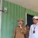 Bupati Gunung Mas Jaya S Monong didampingi Manager PLN ULP Kuala Kurun Rizal Bima Bayuaji, bersiap mengaktifkan meteran listrik salah satu rumah warga Desa Sangal, tanda diresmikannya layanan listrik PLN di desa setempat, Senin (28/8/2023). (GCM/MN-3)
