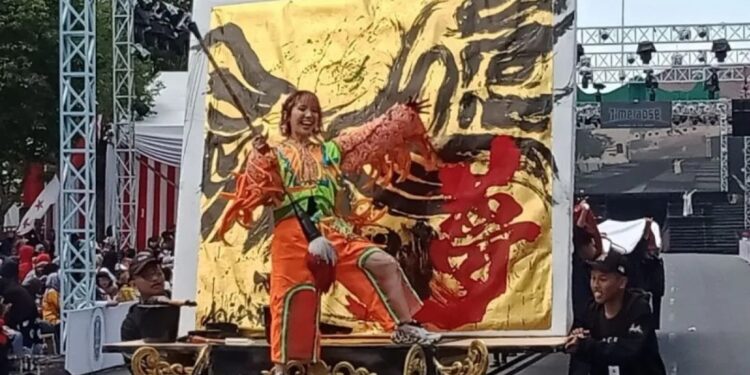 Seniman kaligrafi Jepang Airi Hara saat performance melukis kaligrafi dalam World Kids Carnival di halaman Kantor Pemkab Jember, Sabtu (5/8/2023). (MASAPNEWS/ANT)