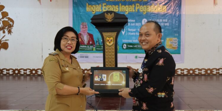 Wabup Gunung Mas Efrensia LP Umbing bertukar cendera mata dengan Pimpinan PT Pegadaian Cabang Palangka Raya Eko Handoko, saat pembukaan seminar di Kuala Kurun, Selasa (25/7/2023). (Foto : Diskominfosantik Kabupaten Gumas)