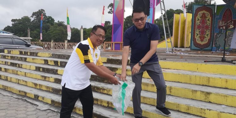 Pj Sekda Gumas Richard dan Ketua Karang Taruna Gumas Isnaini memungut sampah di Taman Kota Kuala Kurun, Jumat (4/8/2023). (IST)