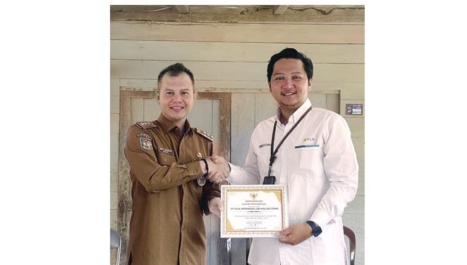 Bupati Gunung Mas Jaya S Monong menyerahkan piagam penghargaan kepada Manager PLN ULP Kuala Kurun Rizal Bima Bayuaji. (IST)