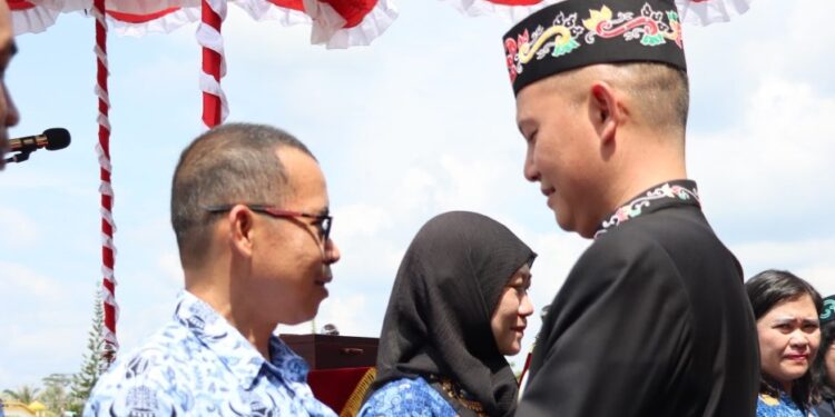 Bupati Gunung Mas Jaya S Monong menyematkan PIN berkarya tanpa narkoba kepada ASN. (IST)