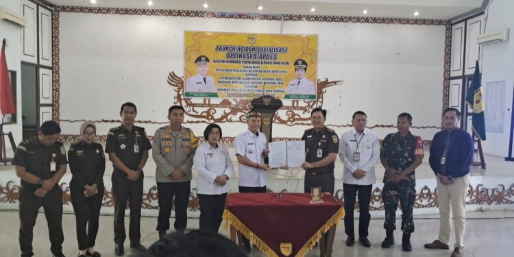 Bupati Gunung Mas Jaya S Monong dan Kajari Sahroni menunjukkan MoU yang baru saja ditandatangani. (MASAPNEWS/GCM)