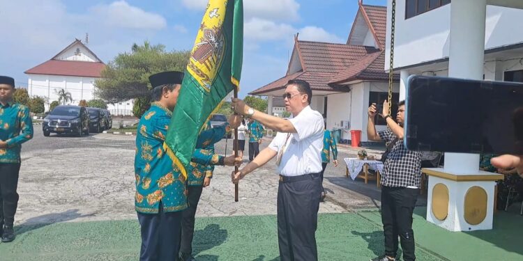 Sekda Gunung Mas Richard menyerahkan duaja kabupaten kepada pimpinan kafilah Gunung Mas Jhonson Ahmad. (MASAPNEWS/GCM)