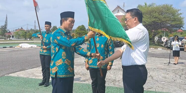 Sekda Gunung Mas Richard menyerahkan duaja kabupaten kepada pimpinan kafilah Gunung Mas Jhonson Ahmad. (MASAPNEWS/GCM)