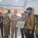 Bupati Gunung Mas Jaya S Monong menyerahkan uang saku kepada salah satu atlet peraih medali. (MASAPNEWS/GCM)