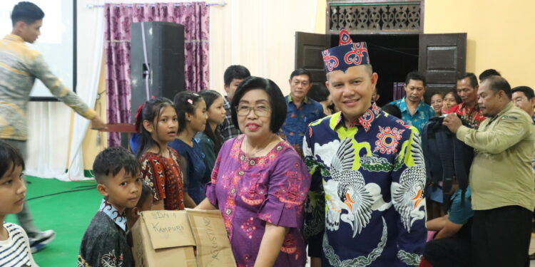 Bupati Gunung Mas Jaya S Monong mendapingi Wakil Bupati Efrensia LP Umbing menyerahkan bantuan Program Gunung Mas Pintar kepada salah satu peserta didik, di sela Safari Natal di Desa Rangan Tate Kecamatan Mihing Raya, Kamis (7/12/2023). (Foto : Diskominfosantik Gunung Mas)