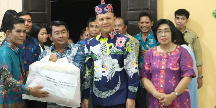 Bupati Gunung Mas Jaya S Monong dan Wakil Bupati Efrensia LP Umbing, mendampingi Kepala Dinas Pendidikan, Kepemudaan dan Olahraga Aprianto serta Kepala Dinsos Jhonson Ahmad, menyerahkan bantuan alat olahraga kepada Lurah Kampuri Junjung Tuah saat Safari Natal di Desa Rangan Tate Kecamatan Mihing Raya, Kamis (7/12/2023). (Diskominfosantik Gunung Mas)