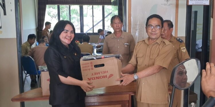 Legislator Gumas Cici Susilawati menyerahkan helm secara simbolis kepada salah satu kades, di Kuala Kurun, Senin (13/5/2024). (IST)