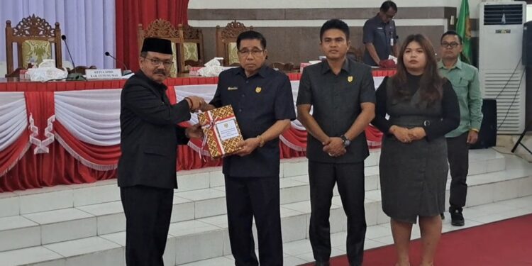 Pj Bupati Gumas Herson B Aden sampaikan Raperda Pertanggungjawaban Pelaksanaan APBD 2023 kepada Ketua DPRD Akerman Sahidar, saat rapat paripurna di Kuala Kurun, Rabu (19/6/2024). (MASAPNEWS/GCM)