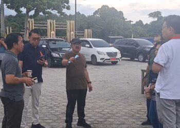 Pj Bupati Gunung Mas Herson B Aden (tengah) dan lainnya berbincang di sela kegiatan gotong royong di Taman Kota Kuala Kurun, Selasa (18/6/2024).