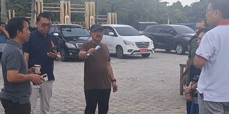 Pj Bupati Gunung Mas Herson B Aden (tengah) dan lainnya berbincang di sela kegiatan gotong royong di Taman Kota Kuala Kurun, Selasa (18/6/2024).