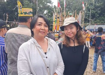 Anggota DPRD Kabupaten Gumas Iceu Purnamasari (kiri) dan buah hatinya saat menghadiri Tabuh Pertama Tiwah massal di Kelurahan Tampang Tumbang Anjir Kecamatan Kurun, Sabtu (8/6/2024). (IST)