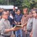 Legislator Kabupaten Gunung Mas Nomi Aprilia (baju garis-garis) mendampingi Asisten III Setda Gumas Letus Guntur saat penyerahan bantuan program pokir untuk pelaksanaan Tiwah massal di Kelurahan Tampang Tumbang Anjir Kecamatan Kurun, Sabtu (8/5/2024). (MASAPNEWS/GCM)