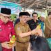 Penjabat Bupati Gumas Herson B Aden menunjukkan paket bahan pokok pada pembukaan pasar murah di Kuala Kurun, Selasa (11/6/2024). (IST)