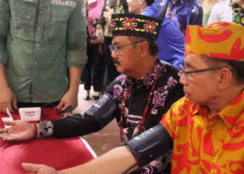 Ketua DPRD Kabupaten Gumas Akerman Sahidar (batik oranye) dan Pj Bupati Herson B Aden, mencoba pelayanan publik pemeriksaan kesehatan di stan pameran pembangunan, di Kuala Kurun, Minggu (16/6/2024). (Foto : Diskominfosantik Gumas)