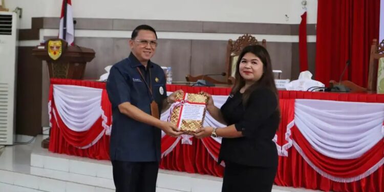 Sekda Gumas Richard menyerahkan Raperda RPJPD 2025-2045 kepada Wakil Ketua II DPRD Gumas Neni Yuliani, saat rapat paripurna di Kuala Kurun, Senin (8/7/2024). (Foto : Diskominfosantik Gumas)