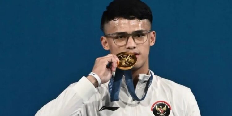 Lifter Indonesia Rizki Juniansyah berpose dengan medali emasnya usai upacara pengalungan medali kelas 73 kg putra Olimpiade Paris 2024 di South Paris Arena, Paris, Prancis, Kamis (8/8/2024). (MASAPNEWS/ANT)