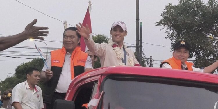 Atlet angkat besi putra Indonesia Rizki Juniansyah (tengah) diarak pada acara pawai keliling Kota Serang, Rabu (14/8/2024). (MASAPNEWS/ANT)