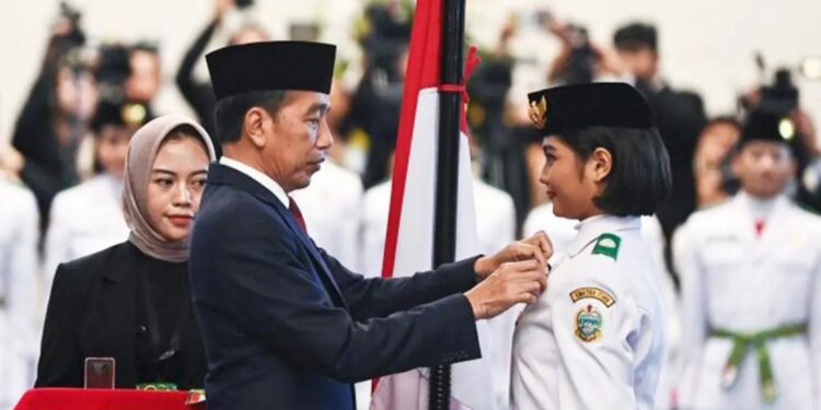 Ilustrasi: Presiden Joko Widodo (tengah) selaku pembina upacara menyematkan lencana kepada anggota Paskibraka 2024 asal Sumatera Utara Violetha Agryka Sianturi dalam pengukuhan Paskibraka Tingkat Pusat 2024 di Istana Negara, Ibu Kota Nusantara (IKN), Kalimantan Timur, Selasa (13/8/2024). (MASAPNEWS/ANT)