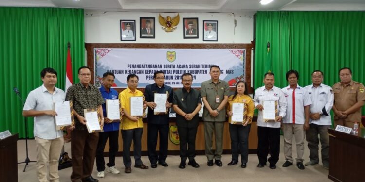 Pj Bupati Gumas Herson B Aden berfoto bersama usai penandatanganan berita acara penyaluran bantuan keuangan parpol tahap pertama di Kuala Kurun, Senin (29/7/2024). (Foto : Diskominfosantik Gumas)