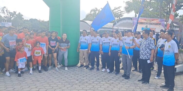 Sekda Kabupaten Gunung Mas Richard mengibarkan bendera start tanda dimulainya lomba lari di Taman Kota Kuala Kurun, Jumat (9/8/2024). (MASAPNEWS/CGM)