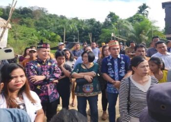 Wakil Ketua I DPRD Gumas Binartha (batik biru tua), Bupati dan Wakil Bupati Gumas periode 2019-2024 Jaya S Monong dan Efrensia LP Umbing, bersama masyarakat menyaksikan tabuh pertama tiwah massal di Desa Tangki Dahuyan Kecamatan Manuhing, Senin (8/7/2024). (IST)