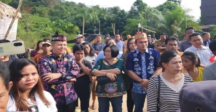 Wakil Ketua I DPRD Gumas Binartha (batik biru tua), Bupati dan Wakil Bupati Gumas periode 2019-2024 Jaya S Monong dan Efrensia LP Umbing, bersama masyarakat menyaksikan tabuh pertama tiwah massal di Desa Tangki Dahuyan Kecamatan Manuhing, Senin (8/7/2024). (IST)