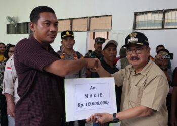 Pj Bupati Gumas Herson B Aden (kanan) menyerahkan bantuan kepada korban kebakaran rumah di Kecamatan Rungan, Minggu (18/8/2024). (IST)