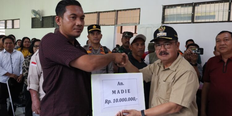 Pj Bupati Gumas Herson B Aden (kanan) menyerahkan bantuan kepada korban kebakaran rumah di Kecamatan Rungan, Minggu (18/8/2024). (IST)