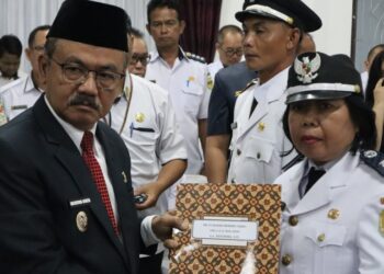 Pj Bupati Gumas Herson B Aden menyerahkan SK kepada salah satu Pj kades yang baru saja dilantik di Kuala Kurun, Rabu (21/8/2024). (Foto : Diskominfosantik Gumas)