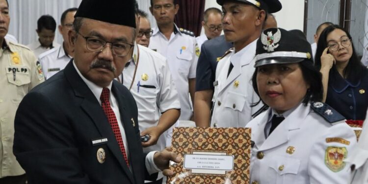 Pj Bupati Gumas Herson B Aden menyerahkan SK kepada salah satu Pj kades yang baru saja dilantik di Kuala Kurun, Rabu (21/8/2024). (Foto : Diskominfosantik Gumas)