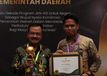 Pj Bupati Gumas Herson B Aden (kiri) dan Kepala BPJS Kesehatan Gumas Adi Suci Guntoro foto bersama usai menerima penghargaan UHC yang diserahkan oleh Wakil Presiden Ma'ruf Amin di Jakarta, Kamis (8/8/2024). (IST)