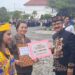 Pj Bupati Gumas Herson B Aden menyerahkan piagam dan uang pembinaan kepada Tumbang Tariak, yang diwakili Ketua BPD Diana di Kuala Kurun, Sabtu (17/8/2024). (IST)