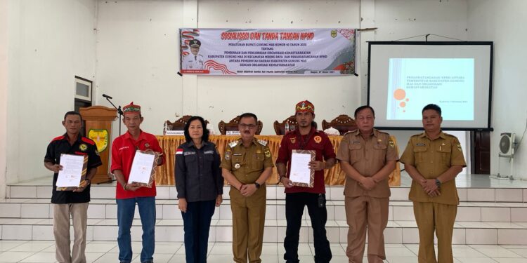 Penjabat Bupati Gumas Herson B Aden (tengah) bersama ormas dan lainnya, menunjukan naskah perjanjian hibah daerah (NPHD) terkait bantuan hibah kepada tiga ormas, di Kelurahan Kampuri Kecamatan Mihing Raya, Senin (7/10/2024). (Foto : Badan Kesbangpol Kabupaten Gumas)