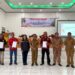 Penjabat Bupati Gumas Herson B Aden (tengah) bersama ormas dan lainnya, menunjukan naskah perjanjian hibah daerah (NPHD) terkait bantuan hibah kepada tiga ormas, di Kelurahan Kampuri Kecamatan Mihing Raya, Senin (7/10/2024). (Foto : Badan Kesbangpol Kabupaten Gumas)