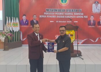 Pj Bupati Herson B Aden (kanan), menerima cendera mata plakat dari Wakil Ketua Bidang Organisasi dan Kaderisasi PPNI Kalteng Budi Paryanto, saat musda IV PPNI kabupaten di Kuala Kurun, Selasa (1/10/2024). (MASAPNEWS)