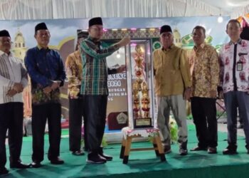Sekda Gumas Richard (batik hijau) menyerahkan piala kepada Camat Rungan Penyang Massal saat penutupan MTQ ke-17 tingkat kabupaten di Kecamatan Rungan, Sabtu malam (26/10/2024). (ist)