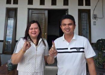 Ketua DPRD Gumas Binartha dan istri menunjukkan jari yang sudah diberi tanda tinta sebagai bukti dirinya telah menggunakan hak pilih di Kelurahan Tumbang Talaken, Rabu (27/11/2024). (IST)
