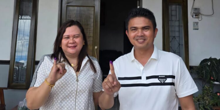 Ketua DPRD Gumas Binartha dan istri menunjukkan jari yang sudah diberi tanda tinta sebagai bukti dirinya telah menggunakan hak pilih di Kelurahan Tumbang Talaken, Rabu (27/11/2024). (IST)