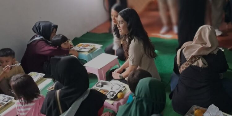 Wamendukbangga Ratu Isyana Bagoes Oka (berbaju cokelat) saat ikut mendistribusikan makan bergizi gratis di Posyandu Dahlia, Kelurahan Susukan, Kecamatan Ciracas, Jakarta Timur, pada Jumat (10/1/2025). (MASAPNEWS/ANT)