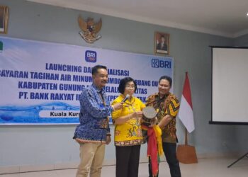 Wakil Bupati Gumas Efrensia LP Umbing (tengah), didampingi Direktur Perumdam Maruang Duhung Hendra Toendan (kiri) dan Pimpinan KCP BRI Kuala Kurun Utas Wenly, memukul katambung tanda diluncurkannya pembayaran tagihan air perumdam melalui layanan BRI, di Kuala Kurun, Selasa sore (18/3/2025). (Foto : MASAPNEWS)